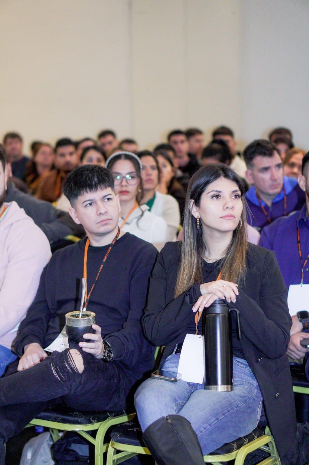 Marcos y Sofía, mate en mano, entre el público de una jornada de formación en kinesiología