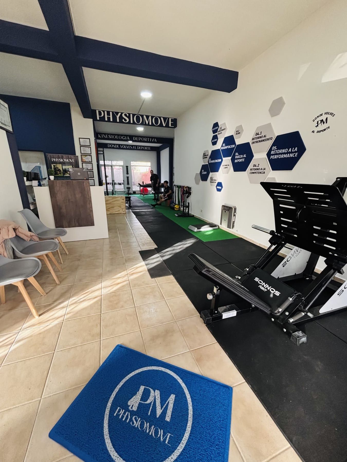 Recepción de PhysioMove con la alfombra del logo PM en el piso