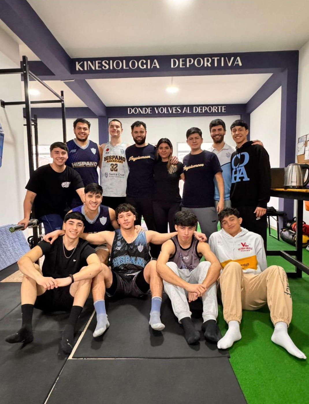 El equipo de PhysioMove junto a un plantel de básquet bajo el cartel Kinesiología Deportiva del centro